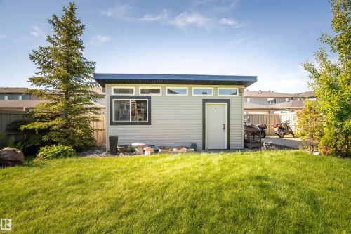 Spacious backyard featuring a contemporary shed with horizontal siding, a flat roof, and black-trimmed windows - 4714 Charles Bay Bay, Edmonton, AB 