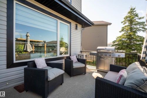 Exterior patio featuring concrete flooring, black metal railings, and light gray siding - 4714 Charles Bay Bay, Edmonton, AB 