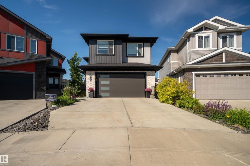 Contemporary exterior featuring horizontal siding, brick accents, and a dark trim - 4714 Charles Bay Bay, Edmonton, AB 