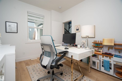 Bright room featuring light wood-finish flooring, white walls, and a large window with blinds - 4714 Charles Bay Bay, Edmonton, AB 