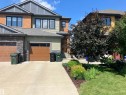 Multi-level facade with stone accents, horizontal siding, and vertical paneling - 94 Tribute Common, Spruce Grove, AB 