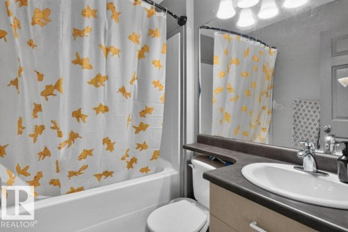 Bathroom featuring a white bathtub, toilet, and vanity with an integrated sink - 21320 90 Avenue, Edmonton, AB 