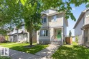 Two-story residential exterior featuring light-colored siding and a contrasting green entry door - 21320 90 Avenue, Edmonton, AB 