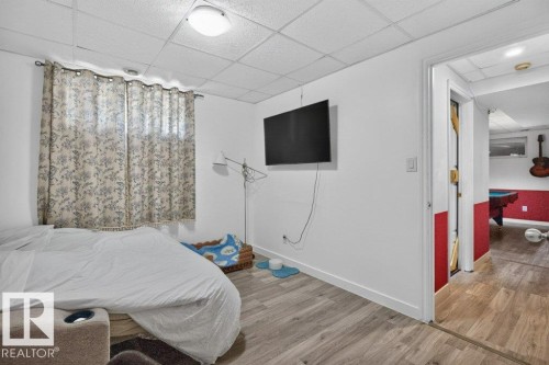 Room featuring wood-finish flooring, white walls, and a drop ceiling - 21320 90 Avenue, Edmonton, AB 