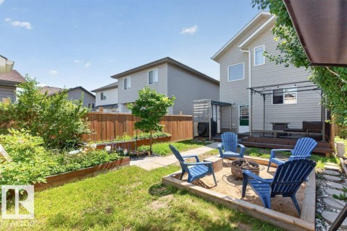 Expansive backyard featuring a dedicated fire pit area, a multi-level wood deck, and a privacy pergola - 21320 90 Avenue, Edmonton, AB 