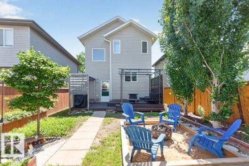 Exterior featuring a rear elevated deck, a concrete pathway, and a sand-filled fire pit area - 21320 90 Avenue, Edmonton, AB 