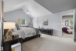 Vaulted ceilings with a ceiling fan, recessed window, dark wood-finish nightstand, and light-toned carpeting - 