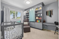 Room featuring soft carpet flooring, built-in shelving with lower cabinetry, a built-in floating desk, and a window with white blinds - 