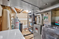 Utility space featuring a water heater and furnace system - 