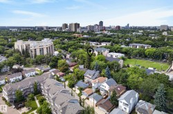 Aerial perspective showcasing a residential area with varied architectural styles, mature trees, and a distant city skyline - 
