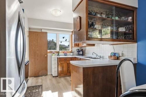 Functional kitchen space featuring wood-finish cabinetry and a light-toned countertop - 10235 74 Street, Edmonton, AB 