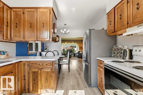 Kitchen featuring wood cabinetry, white countertops, and wood-finish flooring - 10235 74 Street, Edmonton, AB 