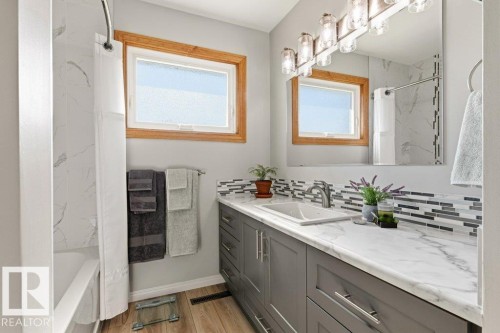 Bathroom with grey vanity cabinetry, a white countertop, and a rectangular undermount sink - 10235 74 Street, Edmonton, AB 