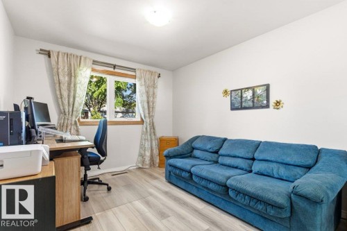 Room featuring light wood-finish flooring, white painted walls, and a ceiling-mounted light fixture - 10235 74 Street, Edmonton, AB 