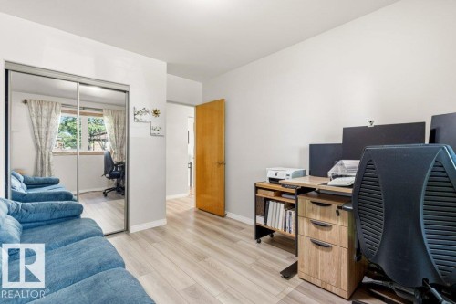 Light wood-finish flooring complements the neutral wall tones - 10235 74 Street, Edmonton, AB 