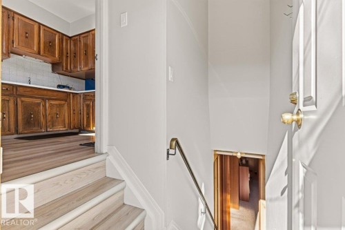 Kitchen with wood-finish flooring and extensive wood cabinetry - 10235 74 Street, Edmonton, AB 