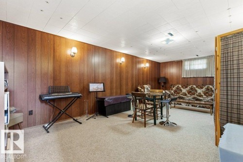 Finished lower level featuring paneled walls, neutral carpeting, and a drop ceiling - 10235 74 Street, Edmonton, AB 