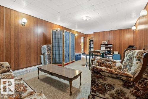 Recreation room featuring wood paneling, wall sconces, ceiling lighting, and carpet flooring - 10235 74 Street, Edmonton, AB 