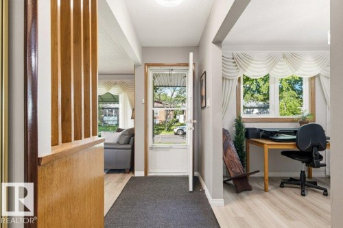 Entryway featuring a storm door, ceiling-mounted light fixture, and light wood-finish flooring - 10235 74 Street, Edmonton, AB 