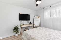 Light wood-finish flooring complements white walls and a white textured ceiling - 