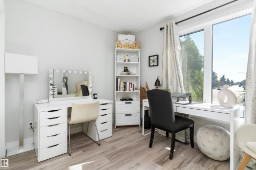 Bright room featuring light wood-finish flooring and a large picture window - 15252 81 Street, Edmonton, AB 