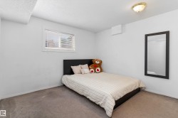 Carpeted room with a single window featuring blinds, a ceiling-mounted light fixture, and white painted walls - 