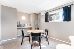 Inviting dining area featuring warm gray wall tones and plush carpet flooring - 
