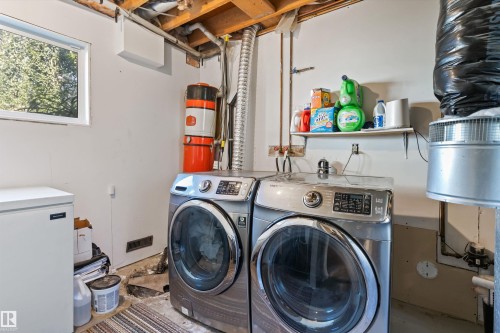Dedicated laundry area featuring exposed ceiling joists and a white-framed window - 15252 81 Street, Edmonton, AB 