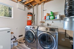Dedicated laundry area featuring exposed ceiling joists and a white-framed window - 