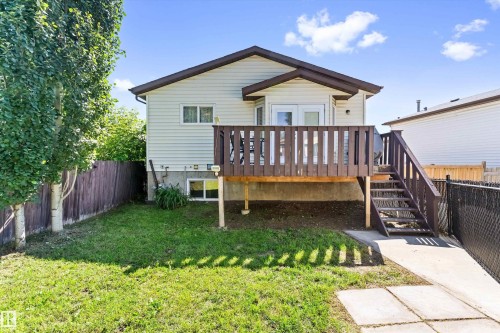 Rear exterior featuring a raised wooden deck with railings, exterior stairs, and a walk-out patio door - 15252 81 Street, Edmonton, AB 