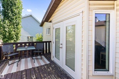 Outdoor deck featuring wood railing, wood-finish flooring, and direct access through double glass panel doors - 15252 81 Street, Edmonton, AB 