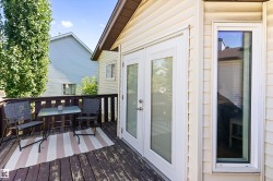 Outdoor deck featuring wood railing, wood-finish flooring, and direct access through double glass panel doors - 