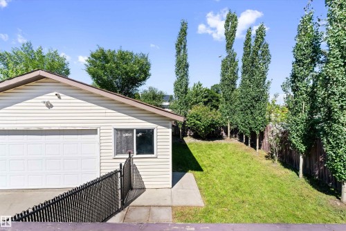 Detached garage with horizontal siding, a white overhead door, and a single window - 15252 81 Street, Edmonton, AB 
