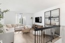 Living area featuring light wood-finish flooring, white walls, and a window with sheer curtains - 15252 81 Street, Edmonton, AB 