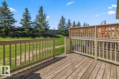 Expansive wooden deck featuring horizontal plank flooring and a painted wood railing - 125 Birchwood Close, Devon, AB 