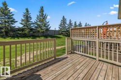 Expansive wooden deck featuring horizontal plank flooring and a painted wood railing - 