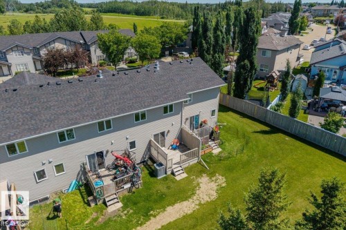 Rear exterior of a two-story residence featuring light gray siding and a dark gray shingle roof - 125 Birchwood Close, Devon, AB 
