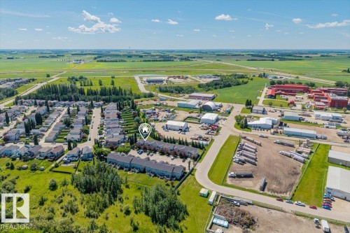 Aerial perspective showcasing residential properties within a developed area, bordered by open fields - 125 Birchwood Close, Devon, AB 