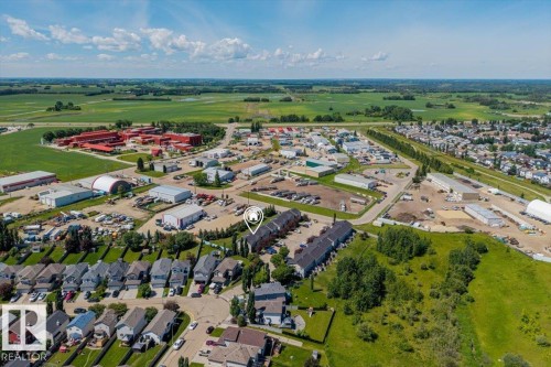 Aerial perspective showcasing residential development with commercial areas and extensive green space - 125 Birchwood Close, Devon, AB 