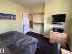 Room featuring light green wall paint, dark patterned carpet, and white trim - 