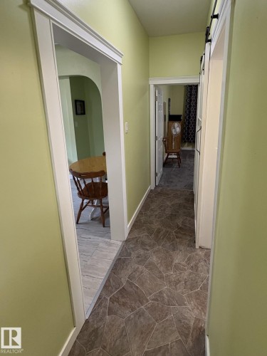Hallway with irregular stone-look flooring, light green walls, and white trim - 11511 101 Street, Edmonton, AB 