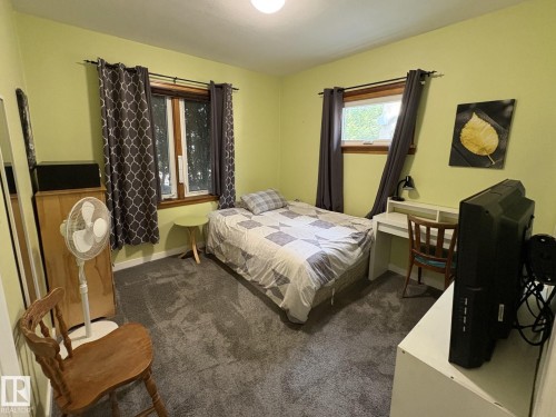 Carpeted room featuring two windows with wood trim, a built-in light fixture, and light-toned walls - 11511 101 Street, Edmonton, AB 