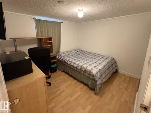 Light wood-finish flooring complements the neutral wall color - 11511 101 Street, Edmonton, AB 
