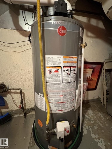 Rheem Performance water heater with yellow gas line, white PVC venting, and associated plumbing - 11511 101 Street, Edmonton, AB 