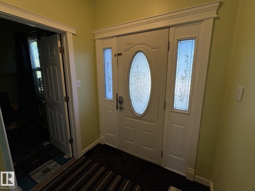 Entryway featuring a white door with an oval etched glass insert, two sidelight windows with decorative glass, and a substantial crown molding trim - 11511 101 Street, Edmonton, AB 