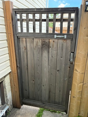 Wood-paneled pedestrian gate with an integrated lattice top and digital keypad entry - 11511 101 Street, Edmonton, AB 