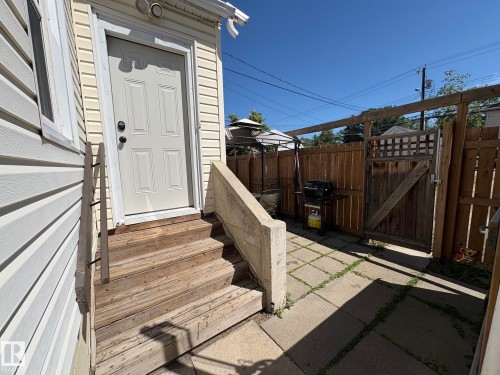Exterior access door with panel detailing, leading to a concrete paver patio - 11511 101 Street, Edmonton, AB 