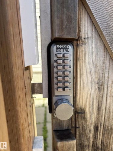 Digital keypad entry system installed on a weathered wood gate - 11511 101 Street, Edmonton, AB 