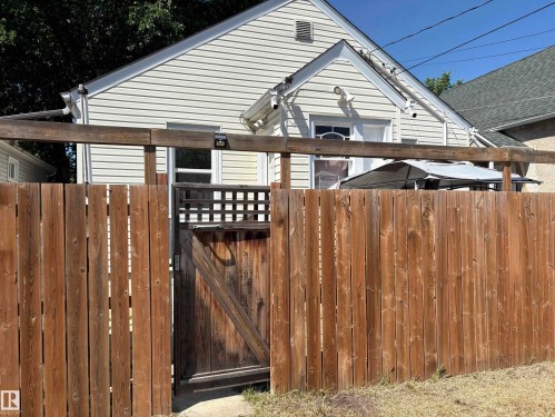 Private backyard featuring a tall wooden fence with a lattice-top gate - 11511 101 Street, Edmonton, AB 