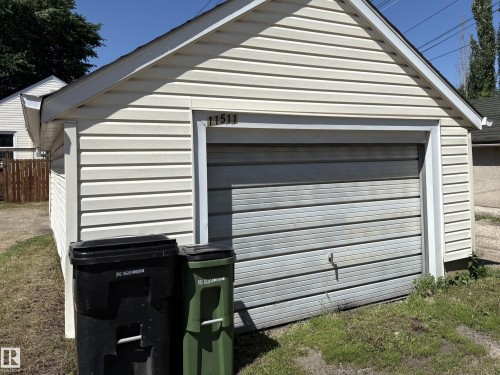 Detached garage featuring horizontal siding and a roll-up garage door - 11511 101 Street, Edmonton, AB 
